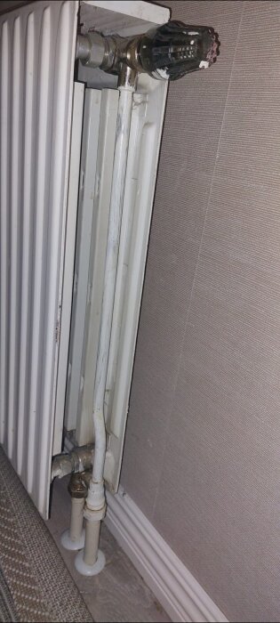 Värmeelement med röranslutningar, en del av ett värmesystem.