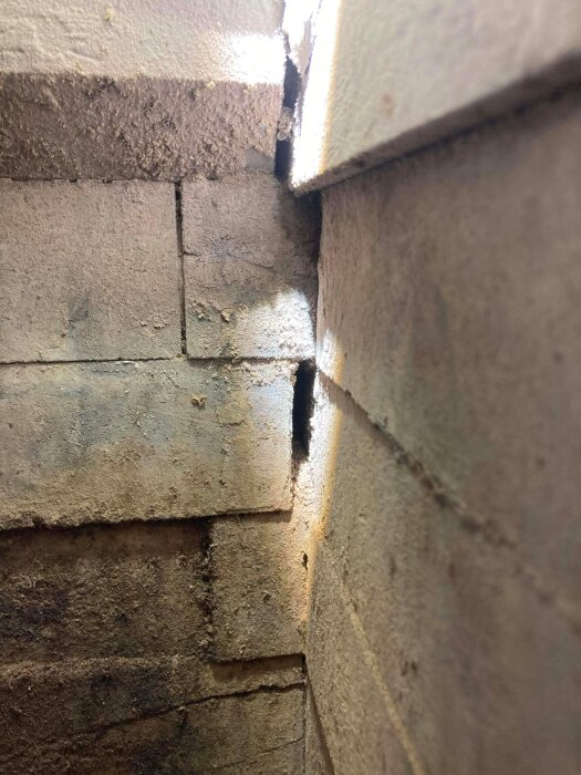 Eldfast tegel med synliga glipor mot väggen utan fogmassa.