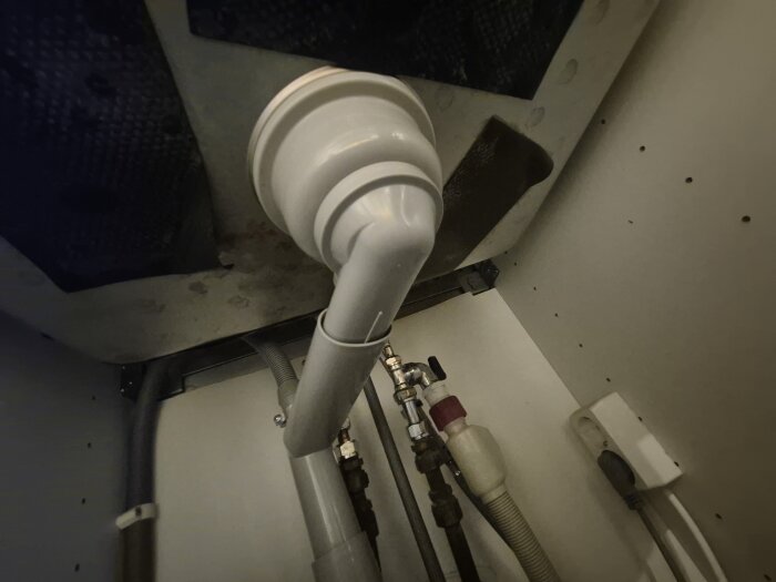 Avloppssystem under diskbänk med rör, slangar och kopplingar anslutna till disktransparenten eller liknande installation.