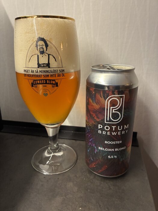 Glas med öl från Potum Brewery, Rooster Belgian Blond 6,5%, bredvid en ölburk med samma etikett och färgglad design, på ett mörkt underlag.