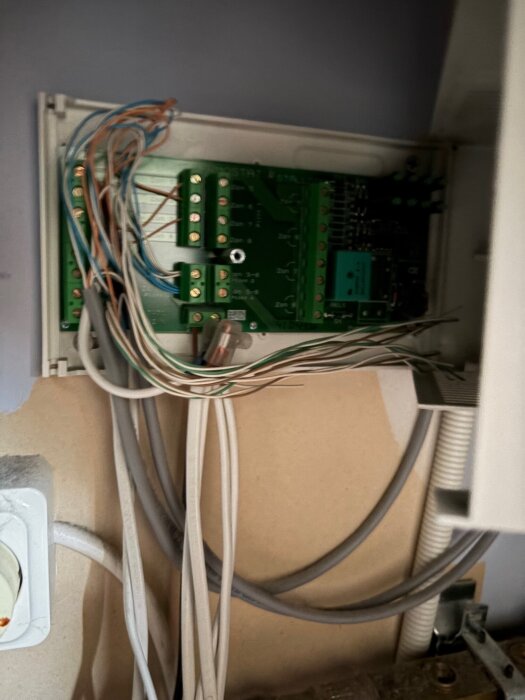 LK kopplingsbox med exponerade ledningar och kretskort, flera anslutna kablar, användarens fråga om eventuella säkringar i boxen.