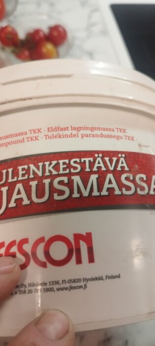 Förpackning av eldfast lagermassa från Fescon med text på flera språk, använd i byggprojekt för att förbereda inför eldningssäsong.