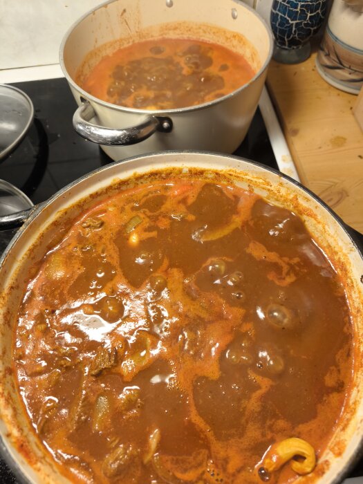 Två grytor med puttrande chiligryta på högrev, en superstark och en mildare, lagade utan Pepsi och vin som ersatts med julmust, öl och starkcider.