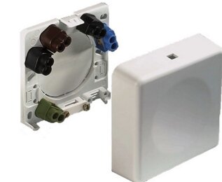 Anslutningsdosa med plintar i olika färger, bredvid ett skyddande överdrag.