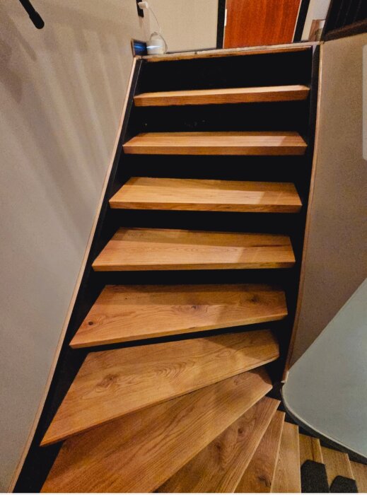 Trappa med trappsteg av parkettgolv, monterad utan trappkontakt i ett hemmabygge.