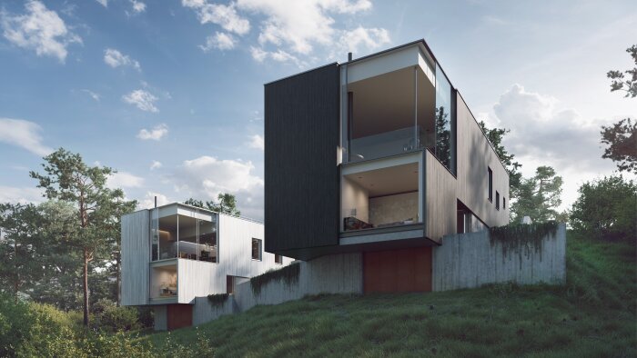 Modernt hus med stora glaspartier på en sluttande gräsbevuxen tomt, omgivet av träd och blå himmel i bakgrunden.