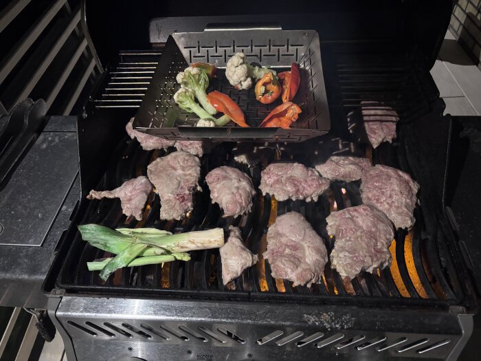 Grillad karré med miniblomkål, paprika och purjolök på en utomhusgrill.