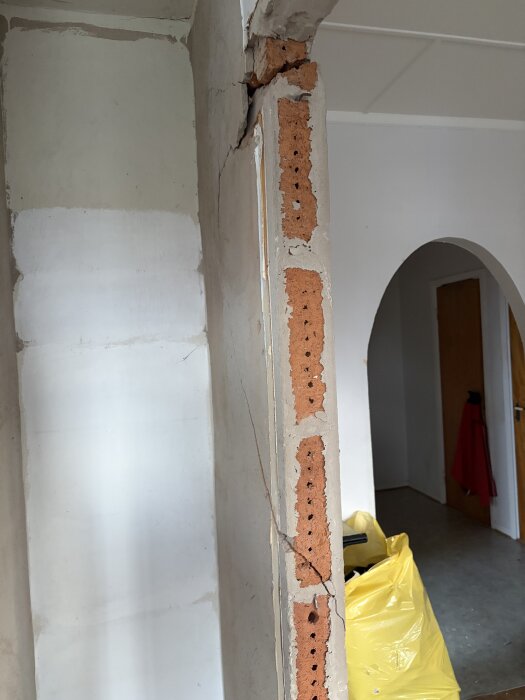 Skadad vägg av lättbetong med spricka synlig i ena hörnet, exponerade murblock. Renoveringsarbete i bostadsrätt från 50-talet.