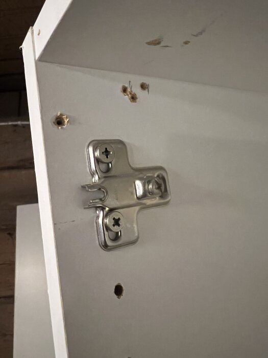 Ett skåpstomme med flera borrhål och ett monterat gångjärn, eventuellt från Ballingslöv.