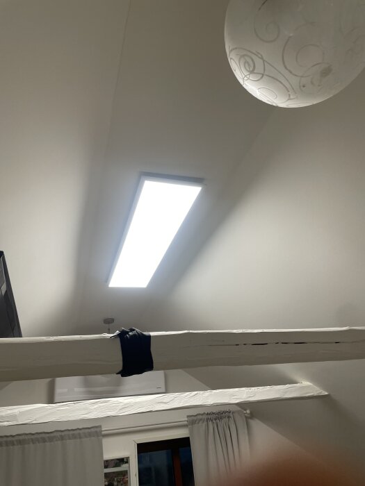 Plafondlampa i sovrum med vit takbjälke och gardiner, förbättrar ljuset i rummet.