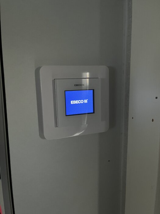 Ebeco EB500 kontrollpanel på vägg med blå skärm i vänteläge, diskussion om oförklarlig viloläge aktiveras i forumtråd om byggprojekt.