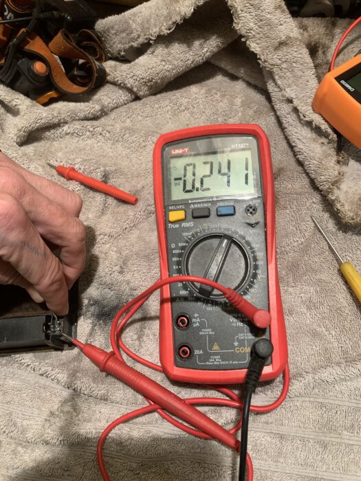 En multimeter visar 0,24 volt, en röd och en svart testledning ansluten, används för att mäta spänning i en Truma-tändare.