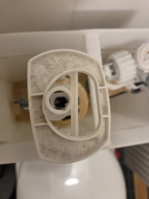 Inre delen av en toalettcistern visar spolknappsmekanism saknar en kopplande del för att aktivera spolning.