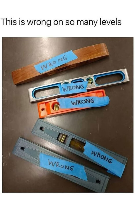 Fyra olika vattenpass på bord med blåa lappar märkta "WRONG".