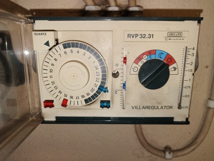 Timer och reglage för en villaregulator med klockinställning och temperaturjustering. Märkt RVP 32.31 av Landis & Gyr.