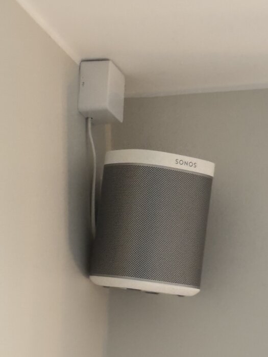 Högtalare monterad på vägg under kopplingsdosa, ansluten med avklippt och skarvad sladd via Wago och buntband för dragavlastning.