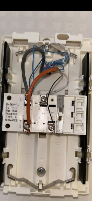 Ringtransformator med flera kablar och terminaler, en orange kabel är ansluten till 8V-uttaget, aktuell fråga är att byta till 12V för en videodörrklocka.