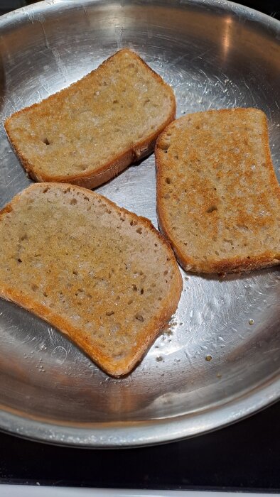 Tre skivor rostat bröd i en stekpanna, förberedda som kvällsmackor.