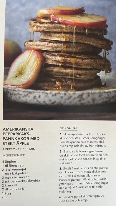 En hög med amerikanska pepparkakspannkakor toppade med stekta äppelskivor och ringlad lönnsirap på en tallrik.