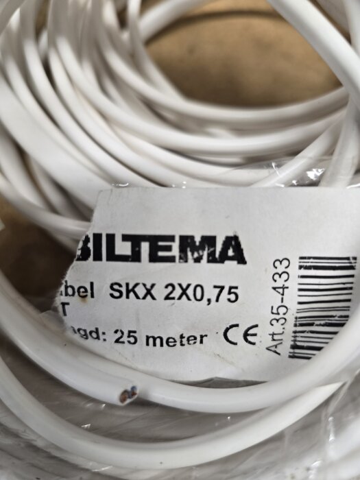 En vit elkabel med etikett, "Biltema SKX 2X0,75", längd 25 meter, syns i bilden.