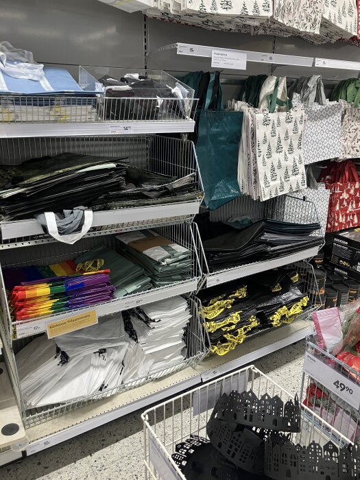 Hylla med färgglada och mönstrade shoppingkassar i en butik, Rusta, med potentiell möjlighet till förstärkning.