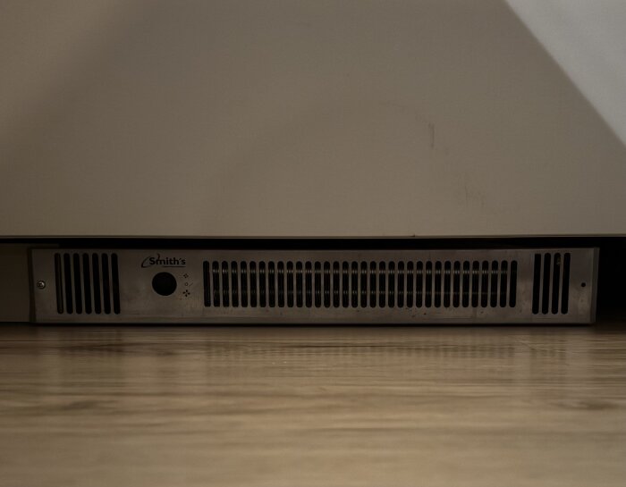 Konvektorelement från Smith's installerat i kökssockel, med ventilationsgaller och kontroller på framsidan.