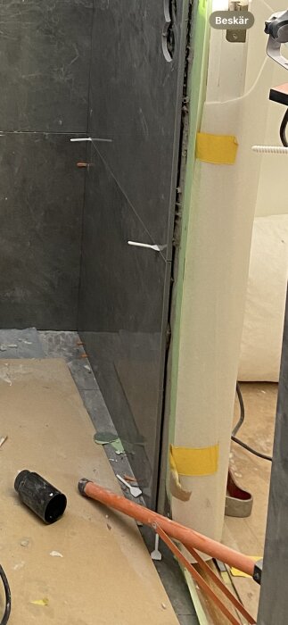 Glipa mellan kakel och vägg där silikonet har släppt, med verktyg och material synliga på golvet.