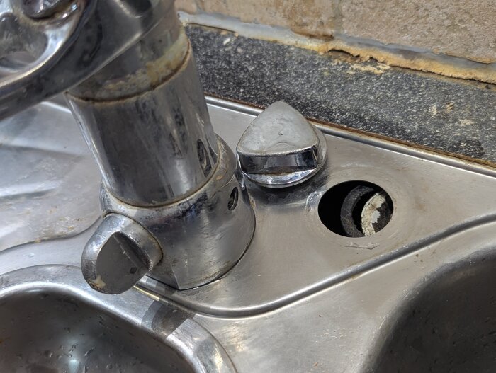 Diskbänk med borttagen ventilvred, visar öppning där packningen är trasig.