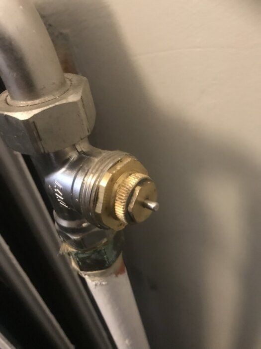 Förbindelse till vattenburet element, visande packbox och ventil i närbild.