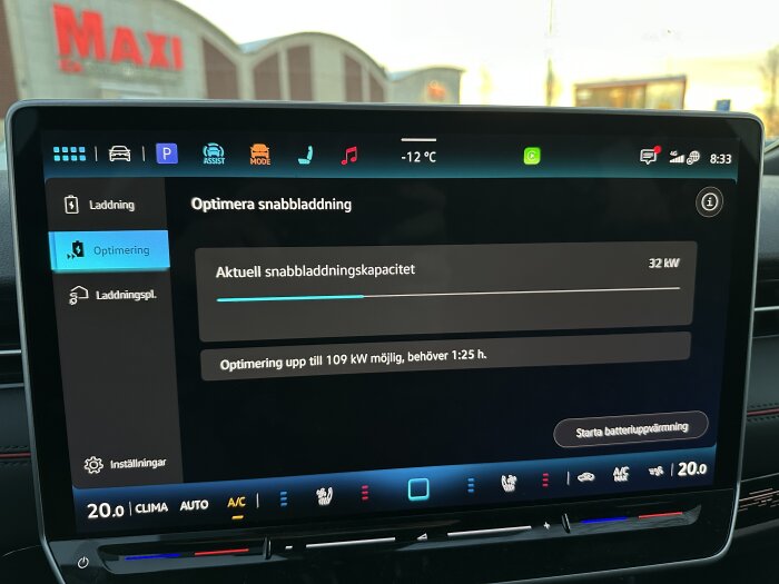 Bilens skärm visar optimering för snabb laddning med aktuell kapacitet på 32 kW vid temperatur -12°C utanför Maxi ICA.