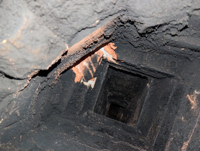 Sotigt rökkanalutrymme med synlig tegelstruktur inuti en skorsten, relaterat till installation av keddy kassett och frågor om sotlucka.