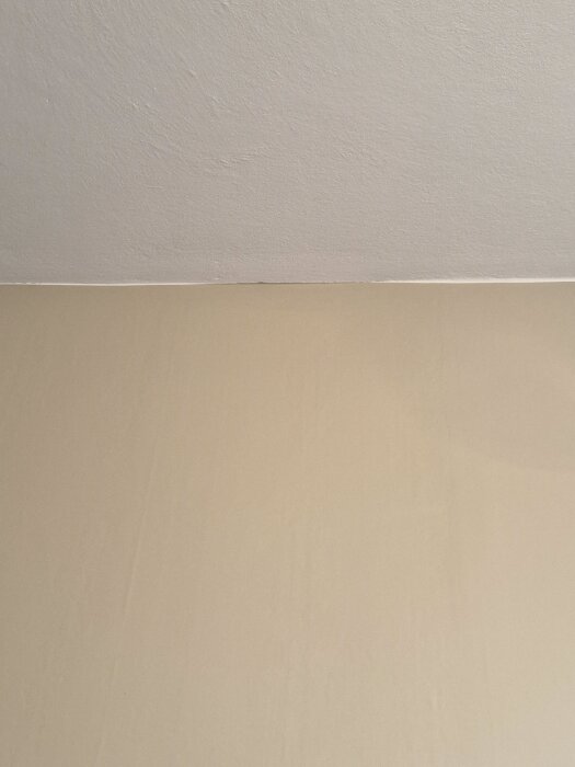 Vit takkant mot ljusbrun vägg; funderingar om målningsstrategi och tejp för att undvika färgläckage.