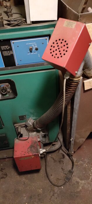 En pelletspanna med sladdar och rör anslutna, avancerade kontroller syns.