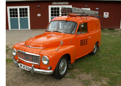 Orange Televerket Volvo Duett framför en verkstad med stege på taket.