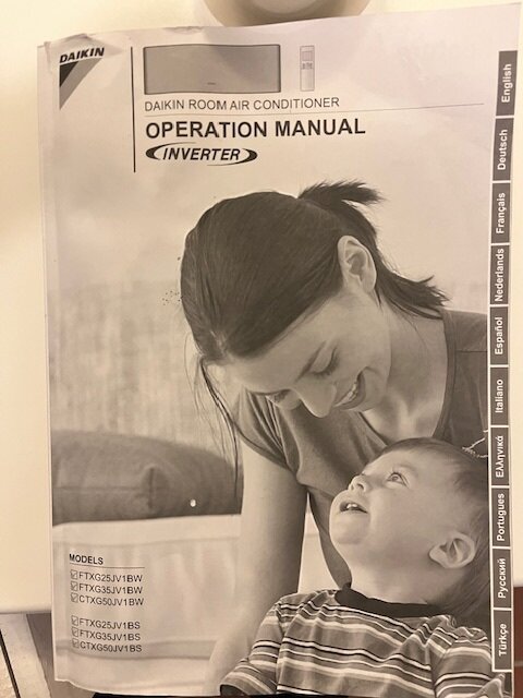 Manual för Daikin luftkonditionering med bild på en kvinna och ett barn som ler mot varandra. Modeller anges på omslaget.