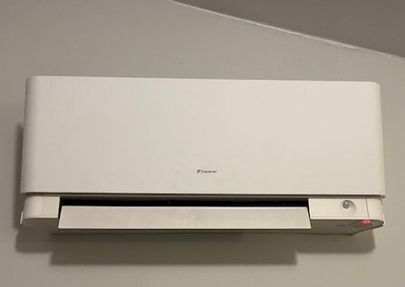 Daikin luftvärmepump modell FTXG25JVBW monterad på en vägg.