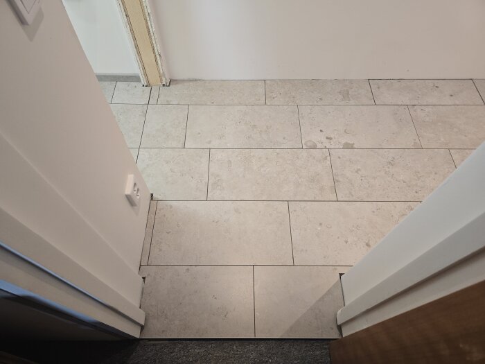 Nyt lagt klinkergolv i en källare med ljusa rektangulära plattor och fogar som bildar ett mönster mellan rummen.