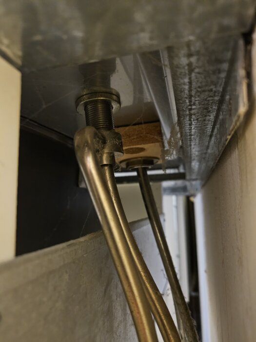 Underifrån bild av tvättställsventil med kopplade vattenrör, där en ventil läcker, kopplad till en tvättmaskin enligt kontext från forumtråd.