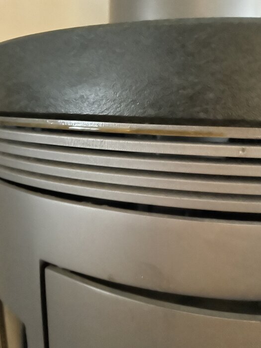 Närbild av en Contura kaminvisande den övre delen med fokus på ventilationsöppningar och yta.