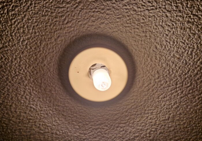 Taklampa med 10W/12V glödlampa monterad i en struktur med texturerad yta.