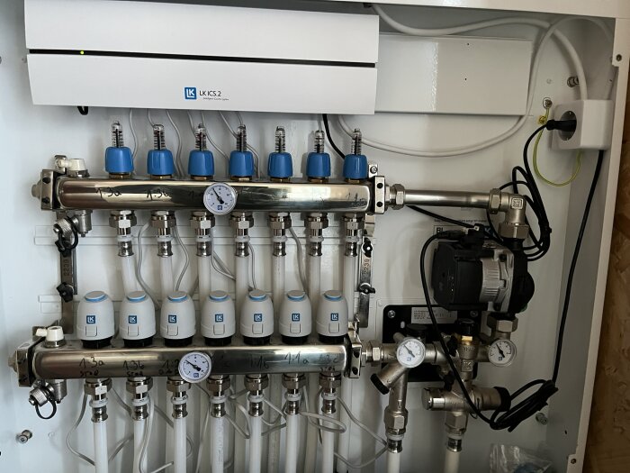 Rördragning och komponenter i ett värmesystem med ventiler, mätare och en Wilo Yonos cirkulationspump.