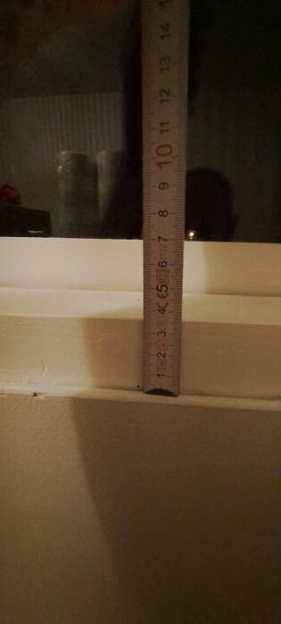 Mätsticka mäter kanten på 6-10 mm mellan fönster och renoveringsgips.