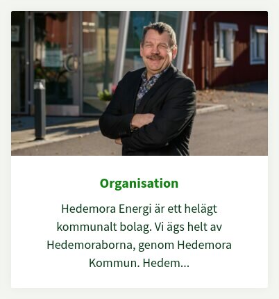 En man i kostym står framför en byggnad med text om Hedemora Energi, ett kommunalt bolag.
