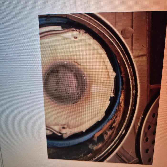 Närbild av en golvbrunn med tätskikt installerat felaktigt, visar synliga skador och behov av reparation i badrumsmiljö.