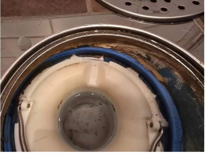 Närbild av en monterad diskhon med en snabblösning för reparation, visar en vit och blå hushållskomponent.