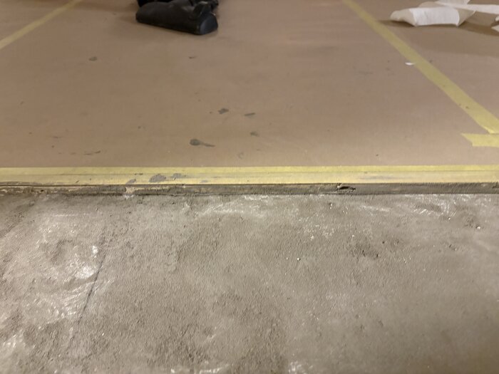 Golv skarv täckt med tape, oskyddad betong synlig för golvprojekt.