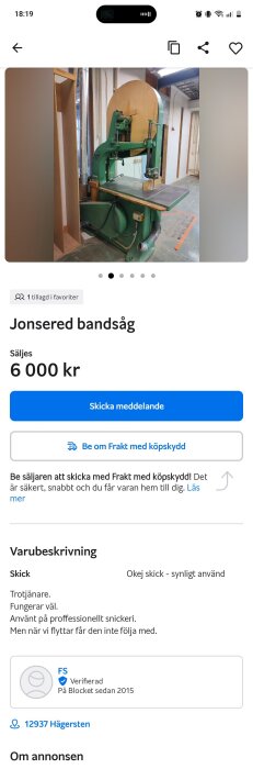 Grön Jonsered bandsåg i ett snickeri, med träbord, synlig motor och ansluten elkabel.