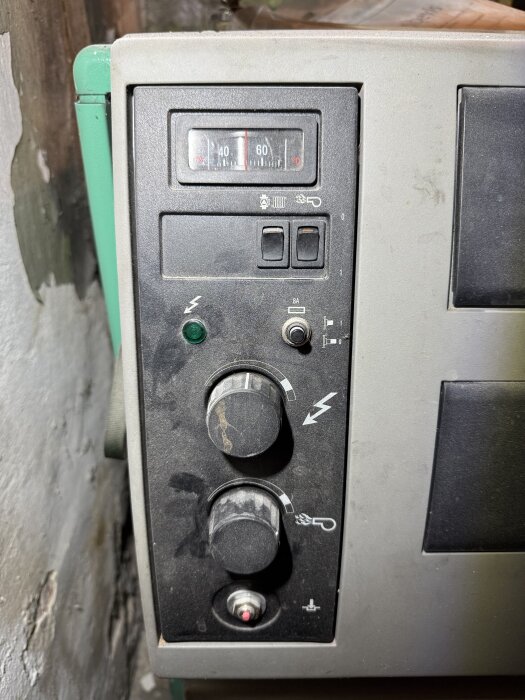 Kontrollpanel för panna med vridreglage och temperaturmätare, används för att ställa in inställningar för olja och värme.