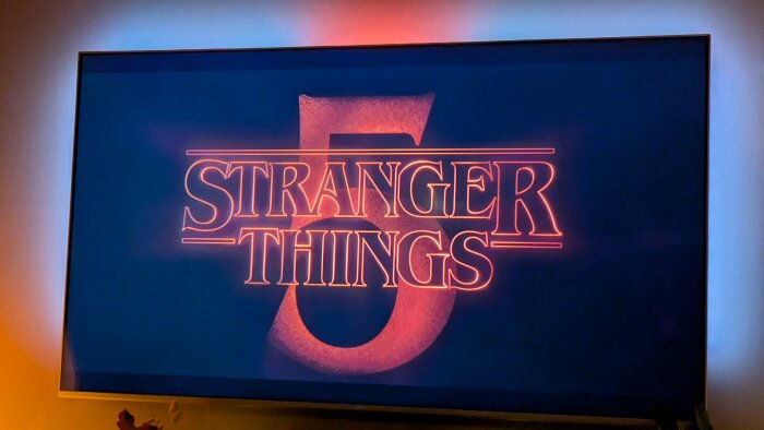 TV-skärm med logotypen "Stranger Things 5" i röd neonstil mot svart bakgrund.