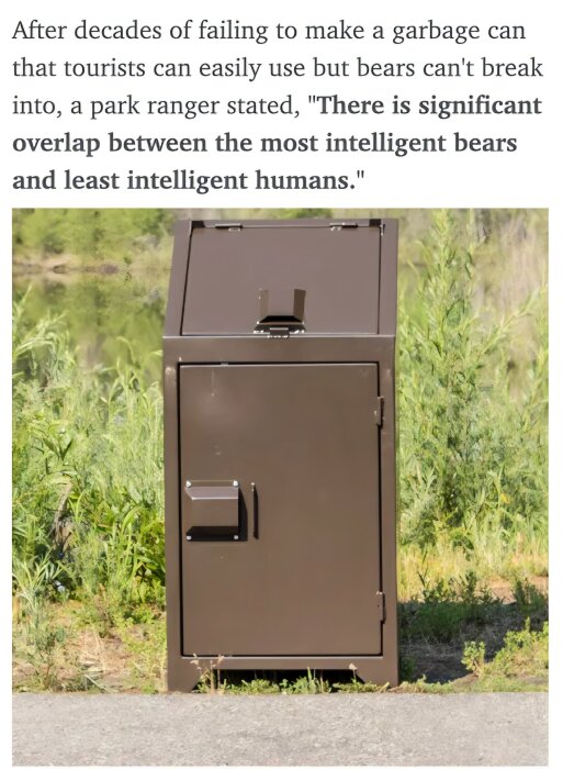 Brun metallavfallsbehållare i naturmiljö för att avskräcka björnar, placerad på en gångväg med grönska i bakgrunden.